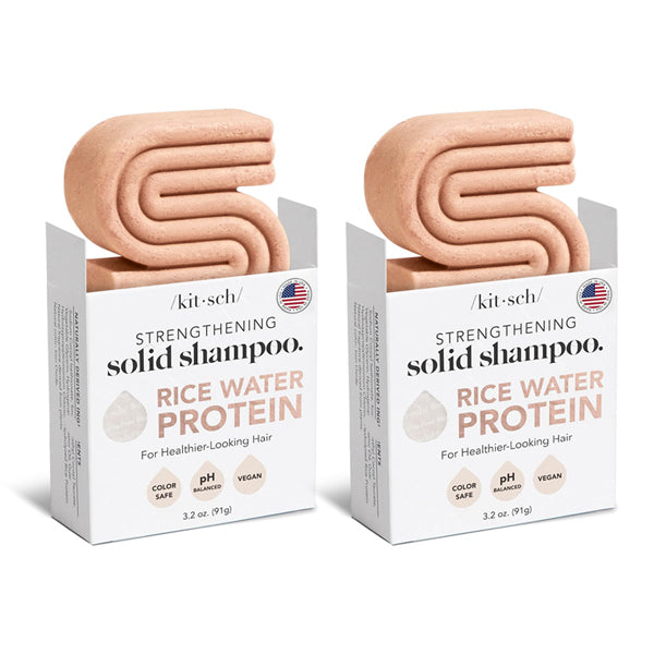 Two boxes of Kitsch All Natural Rice Water Strengthening Shampoo Bar 3.2oz (2 Pack) by Kitsch, featuring pink, S-shaped solid bars partially out of the packaging for healthy hair growth.